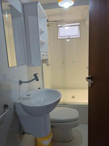 uma casa de banho com um lavatório, um WC e uma janela. em Flor de Canela em São Roque