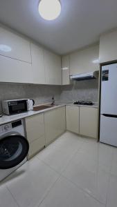 a kitchen with white cabinets and a white refrigerator at Samarkand Central Apartments in Samarkand