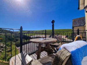 a table and chairs on a balcony with a view at Beachcombers Apartments in Newquay