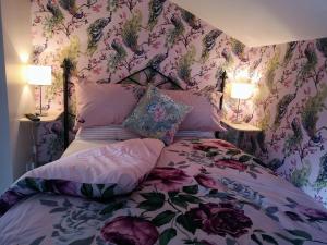 Schlafzimmer mit einem Bett mit Blumentapete in der Unterkunft Brampton Dales Farm in Gainsborough