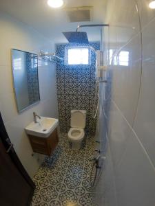 Baño pequeño con aseo y lavamanos en Najmi Inn Hotel, 