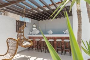 a patio with a bar with chairs and tables at Lino Mare Boutique Hotel in Amoudara Herakliou