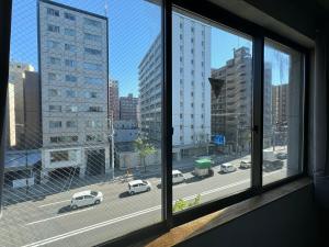 a view of a city street from a window at Untapped Hostel in Sapporo