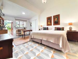 a bedroom with a bed and a desk and a kitchen at The Melville Quarters in Johannesburg