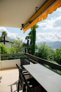 einen Tisch und Stühle auf einem Balkon mit Aussicht in der Unterkunft Residenza la Promenada App 4242 in Orselina
