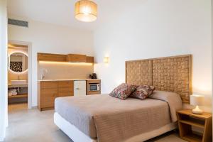 a bedroom with a bed and a small kitchen at Arancia Elegant Rooms and Suites in Tolo