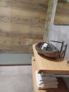 baño con lavabo de piedra en una encimera de madera en Agriturismo al pra di muriet, en Susa