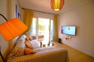 Una sala de estar con un sofá y un televisor de pantalla plana. en Bajo de 2 dormitorios en Puerto Rey, en Vera