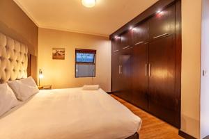 ein Schlafzimmer mit einem großen Bett und einem Schrank in der Unterkunft Modern 1 Bedroom Apartment No Loadshedding in Kapstadt + 38 Fotos