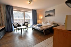 ein Hotelzimmer mit einem Bett und Stühlen und einem Fenster in der Unterkunft Haus Königsdüne II/8 in Borkum