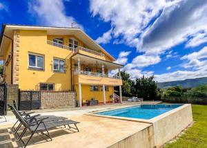 een huis met een zwembad ervoor bij Amplia casa con piscina y zona de juegos in Villabáñez