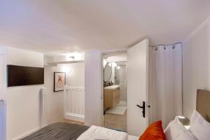 1 dormitorio con 1 cama y baño con lavamanos en SUEDE PROMENADE Duplex apartment at 1 min from the sea 2 baths, en Niza