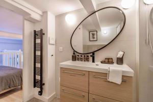 La salle de bains est pourvue d'un lavabo et d'un miroir. dans l'établissement SUEDE PROMENADE Duplex apartment at 1 min from the sea 2 baths, à Nice
