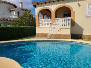 a swimming pool in front of a house at Sol y Mar in Oliva