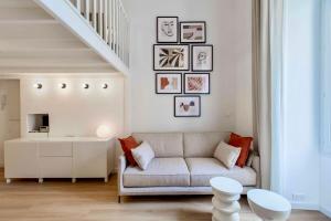 una sala de estar con sofá y algunas fotos en la pared en SUEDE PROMENADE Duplex apartment at 1 min from the sea 2 baths, en Niza