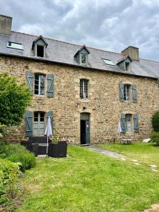 a large brick building with a grass yard at Appart'hotel Maison Saint Michel in Paimpol
