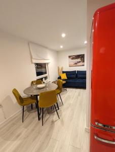 a dining room with a table and chairs and a couch at White Shell Apartament Hel in Hel
