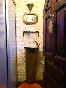 baño con lavabo y espejo en la pared en Charmant Ryad à 1mn de BAB BOUJLOUD DAR SERRAJ, en Fez