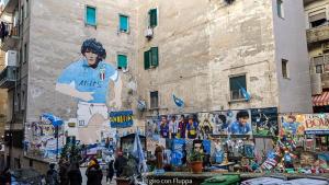 un bâtiment orné d'une fresque murale représentant un joueur de football. dans l'établissement Da basso experience Napoli via Toledo, Pompeii, Ercolano and Vesuvio, à San Giorgio a Cremano