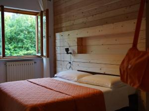een slaapkamer met een bed met een houten muur bij B&B Porto Del Bivio in Duino