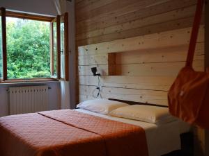 a bedroom with a bed with a wooden wall at B&B Porto Del Bivio in Duino