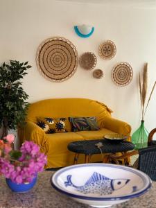 sala de estar con sofá amarillo y mesa en Casa Violetta, en Lotzorai