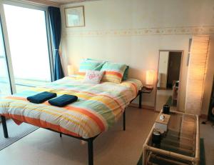a bedroom with a bed with two pillows on it at 3 Studios - 3 Ambiances - Tout confort - Chez Maud et Danny - Piscine extérieure chauffée ouverte en Juillet et Août in Han-sur-Lesse