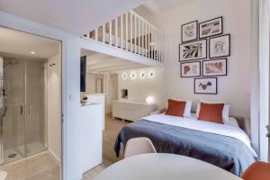 1 dormitorio blanco con 1 cama y escalera en SUEDE PROMENADE Duplex apartment at 1 min from the sea 2 baths, en Niza