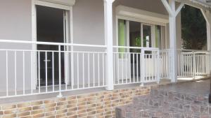 un porche con barandillas blancas en una casa en Ka Villa Location en Pointe-Noire