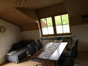 a dining room with a table and chairs and a bed at FeWo Tannerbauer in Regen