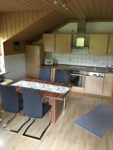 Una cocina con una mesa y sillas de madera. en FeWo Tannerbauer, en Regen