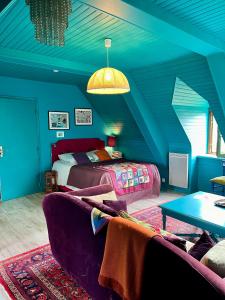 Habitación azul con cama y sofá en Appart'hotel Maison Saint Michel, en Paimpol