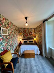1 dormitorio con cama y papel pintado colorido en Appart'hotel Maison Saint Michel en Paimpol