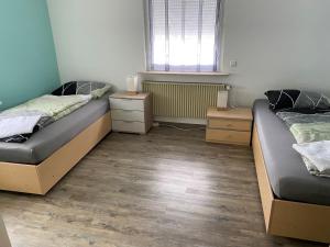1 Schlafzimmer mit 2 Betten und 2 Nachttischen in der Unterkunft Ferienwohnung Pfeifer in Friedrichsdorf