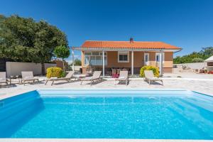 een villa met een zwembad en een huis bij Holiday Home LaMar - with heated pool and whirlpool in Raštević