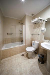 a bathroom with a toilet and a tub and a sink at Hostal Las Fuentes in Madrid
