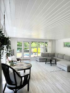 a living room with a couch and a table at Charming Summer House On A Secluded Plot in Glesborg