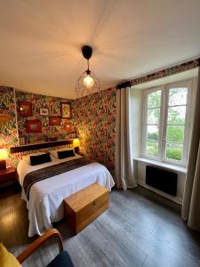 a bedroom with a bed and a large window at Appart'hotel Maison Saint Michel in Paimpol