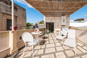 um pátio com cadeiras e uma mesa na varanda em Dimora con terrazza vicino Otranto em Muro Leccese