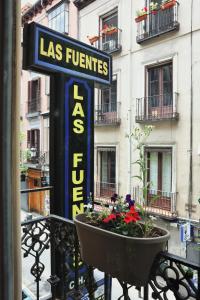 a sign on a balcony with a pot of flowers at Hostal Las Fuentes in Madrid