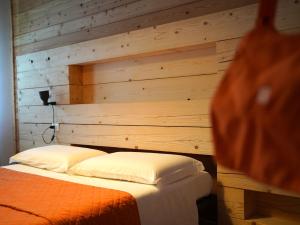 a room with a bed with a wooden wall at B&B Porto Del Bivio in Duino