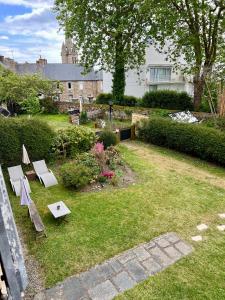 un jardín con dos bancos y una mesa en el césped en Appart'hotel Maison Saint Michel en Paimpol