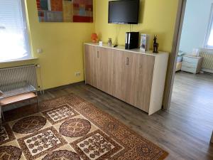 a living room with a tv on top of a cabinet at Ferienwohnung Pfeifer in Friedrichsdorf +3 photos