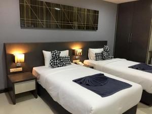 A bed or beds in a room at At Sakon Hotel