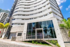 a tall white building with glass windows at Studio Encantador - Garagem - Piscina na Cobertura in João Pessoa