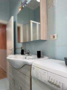 y baño con lavabo blanco y espejo. en Casa Affitto Breve Frattamaggiore, en Frattamaggiore