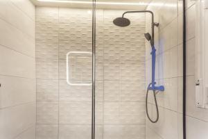y baño con ducha y puerta de cristal. en Metropolitano en Madrid en Madrid