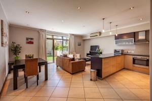 eine Küche und ein Wohnzimmer mit Tisch und ein Esszimmer in der Unterkunft Modern 1 Bedroom Apartment No Loadshedding in Kapstadt