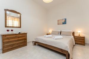 a bedroom with a bed with two towels on it at Villa Grevillea Mikri Vigla in Mikri Vigla