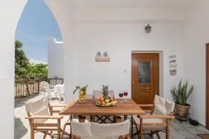 a dining room with a wooden table and chairs at Villa Grevillea Mikri Vigla in Mikri Vigla
